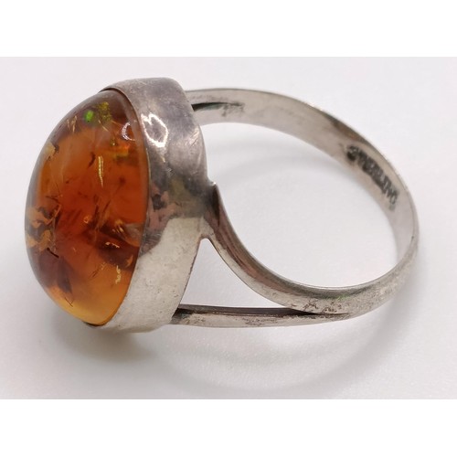 769 - A pair of silver and amber stud earrings, a similar ring, an amber coloured stone pendant (3)