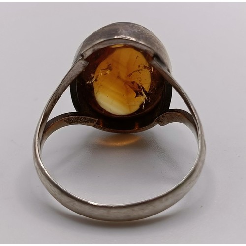 769 - A pair of silver and amber stud earrings, a similar ring, an amber coloured stone pendant (3)