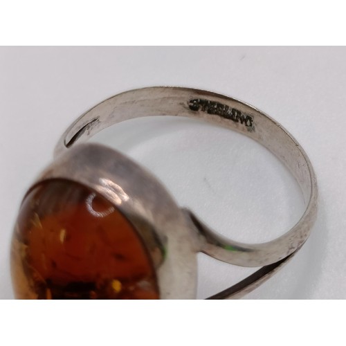 769 - A pair of silver and amber stud earrings, a similar ring, an amber coloured stone pendant (3)