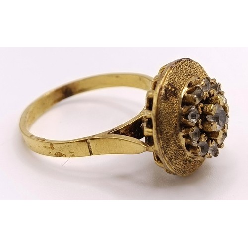 797 - A gilt metal and white stone ring, and a gold plated flower brooch (2)