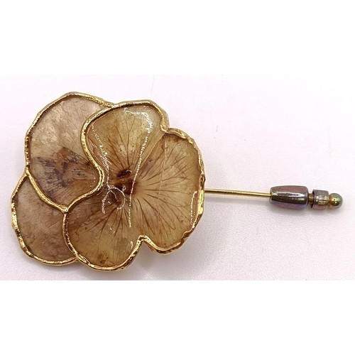 797 - A gilt metal and white stone ring, and a gold plated flower brooch (2)