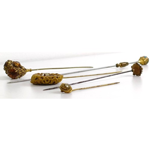 823 - A gilt metal, opal and white stone hairpin, and four other hairpins