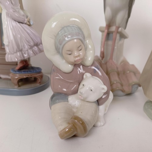 596 - A Lladro figure of a girl cleaning a longcase clock, with a cat on top of the clock, two other Lladr... 