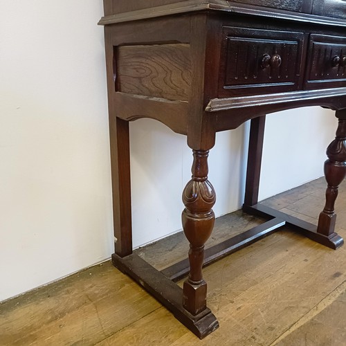 927 - An oak cupboard on stand, having a pair of linen fold panel doors above a drawer, 77 cm wide