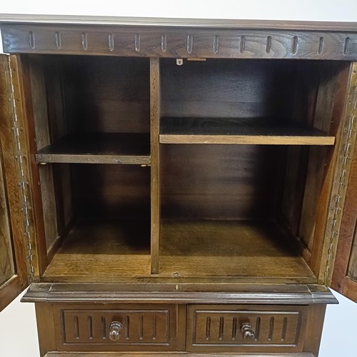 927 - An oak cupboard on stand, having a pair of linen fold panel doors above a drawer, 77 cm wide