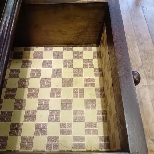 927 - An oak cupboard on stand, having a pair of linen fold panel doors above a drawer, 77 cm wide