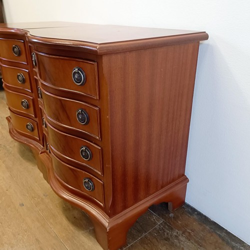 928 - A pair of modern mahogany serpentine front bedside chests, having four drawers, 43 cm wide