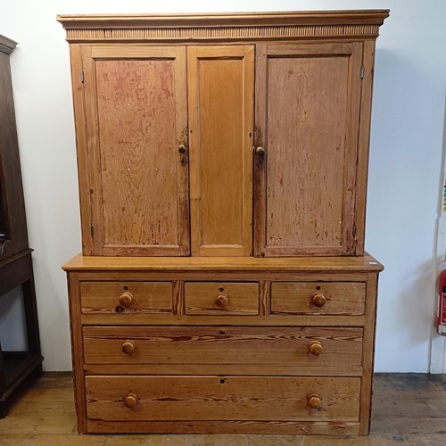 943 - A pine housekeepers style cabinet, the top having two cupboard doors, the base with three short and ... 