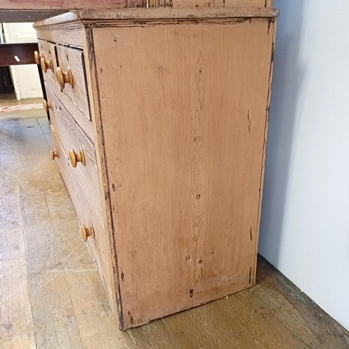 943 - A pine housekeepers style cabinet, the top having two cupboard doors, the base with three short and ... 