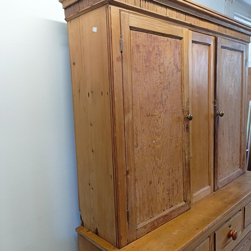 943 - A pine housekeepers style cabinet, the top having two cupboard doors, the base with three short and ... 