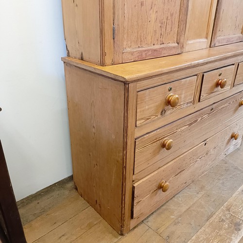 943 - A pine housekeepers style cabinet, the top having two cupboard doors, the base with three short and ... 