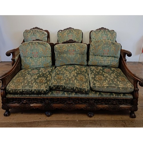 960 - A bergere suite, with a carved mahogany frame, double caned arms and back, some losses, comprising a... 