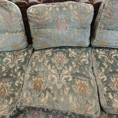 960 - A bergere suite, with a carved mahogany frame, double caned arms and back, some losses, comprising a... 