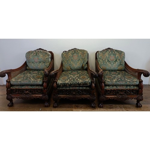 960 - A bergere suite, with a carved mahogany frame, double caned arms and back, some losses, comprising a... 