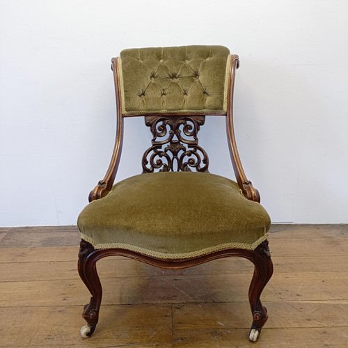 962 - A 19th century walnut framed nursing chair, with a carved pierced back