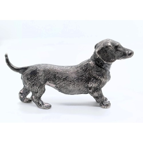 717 - A silver figure of a dachshund, London, 1972, 77g,  6 cm wide, and a continental silver figure of a ... 