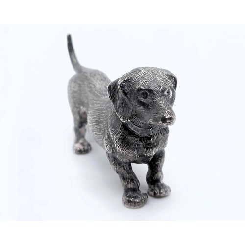 717 - A silver figure of a dachshund, London, 1972, 77g,  6 cm wide, and a continental silver figure of a ... 