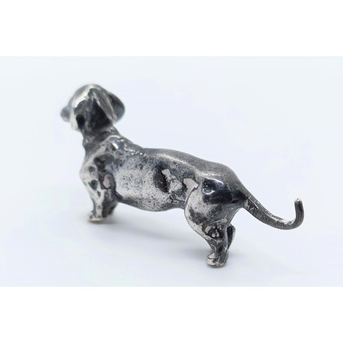 717 - A silver figure of a dachshund, London, 1972, 77g,  6 cm wide, and a continental silver figure of a ... 