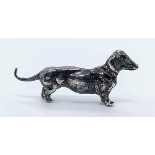 717 - A silver figure of a dachshund, London, 1972, 77g,  6 cm wide, and a continental silver figure of a ... 