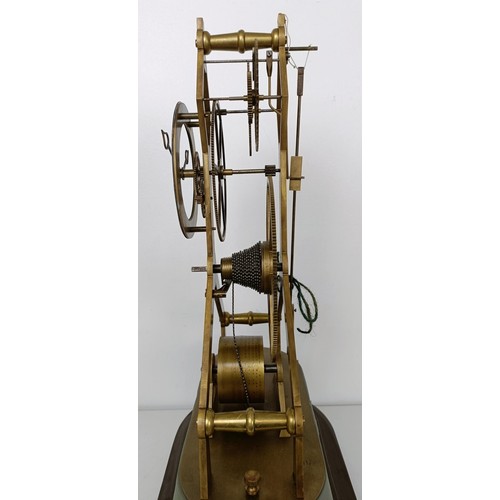 883 - A skeleton clock, with an enamel dial fitted a single fusee movement, on an ebonized base under a gl... 