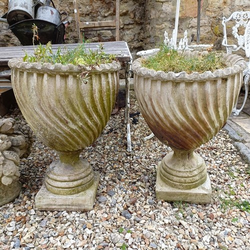 1075 - A pair of composite stone garden urns, 48 cm diameter