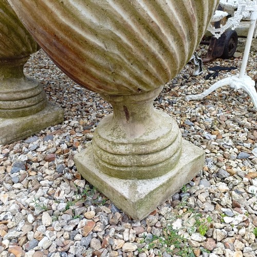 1075 - A pair of composite stone garden urns, 48 cm diameter