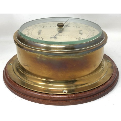 858 - A ship's barometer, by J N Taylor & Co, Adelaide, in a brass case with a mahogany mount, 24 cm d... 