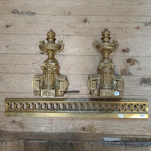 1070 - A gilt metal fender, with urn finials, 124 cm wide