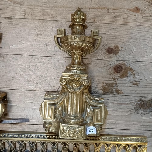 1070 - A gilt metal fender, with urn finials, 124 cm wide