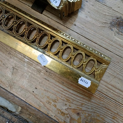 1070 - A gilt metal fender, with urn finials, 124 cm wide