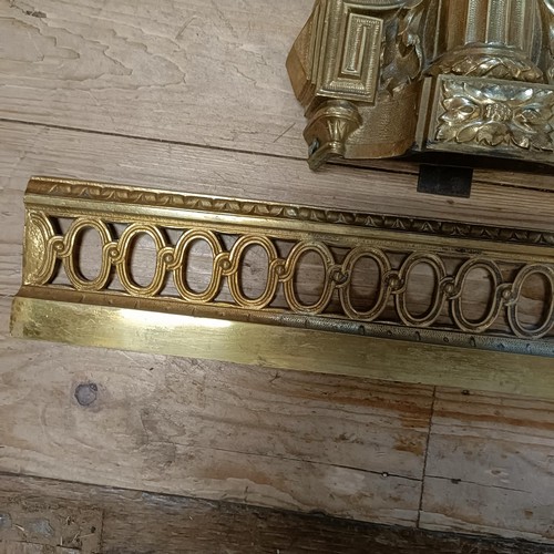 1070 - A gilt metal fender, with urn finials, 124 cm wide