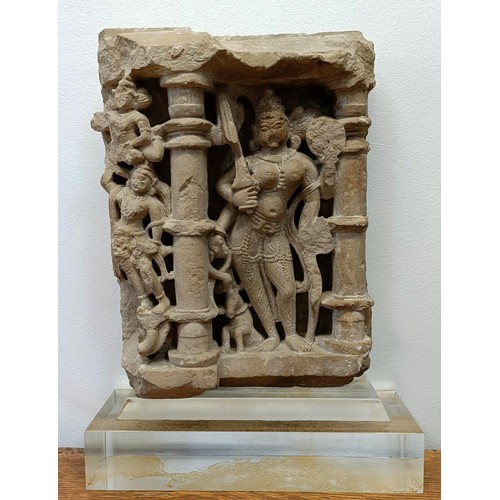 685 - A carved stone temple carving, decorated figure, in a perspex mount, 43 x 30 cm