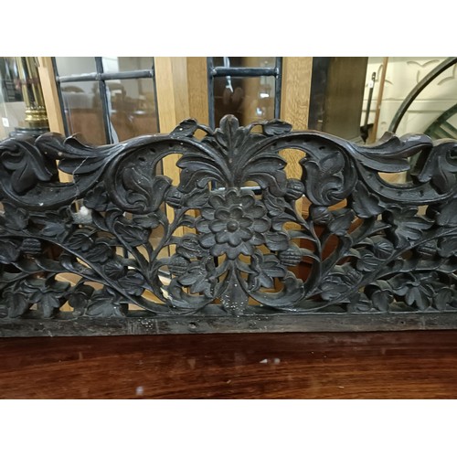 973 - A Burmese serpentine front table, profusely carved with foliate and animal forms, 135 cm wide