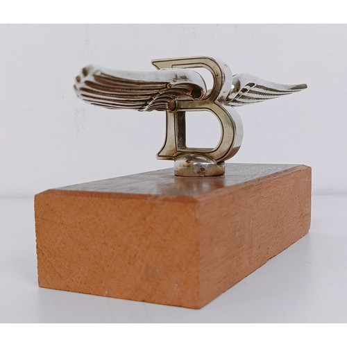 459 - A small Bentley Winged B mascot, wingspan 17 cm, mounted on a wooden block