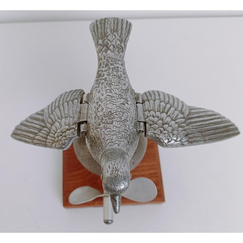 472 - A rare and unusual mechanical racing pigeon car mascot, with a later propeller, mounted on wooden ba... 