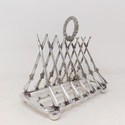 710 - A late Victorian silver plated novelty toast rack, the division in the form of shotguns, 16 cm wide