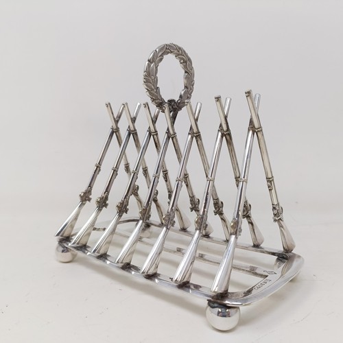 710 - A late Victorian silver plated novelty toast rack, the division in the form of shotguns, 16 cm wide