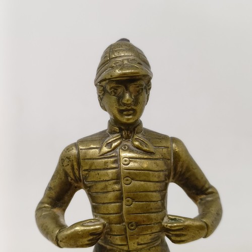 717 - A brass car mascot, in the form of a jockey, on a later wooden base, 16 cm high