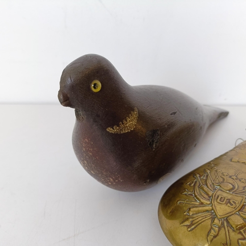 727 - A painted wooden decoy, in the form of a pigeon and a brass powder flask (2)