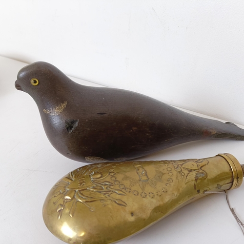 727 - A painted wooden decoy, in the form of a pigeon and a brass powder flask (2)