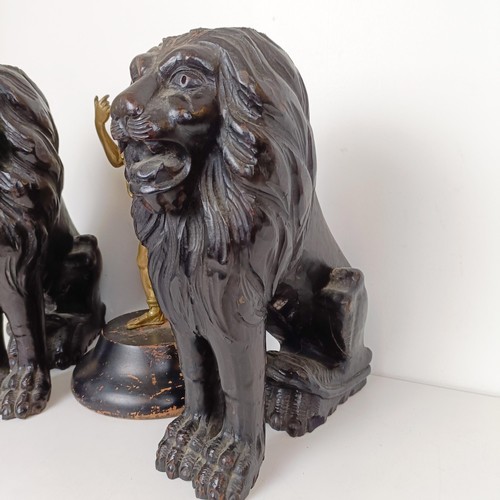 850 - A pair of carved wooden lions, 36 cm high, and a brass figure of a centurion (3)