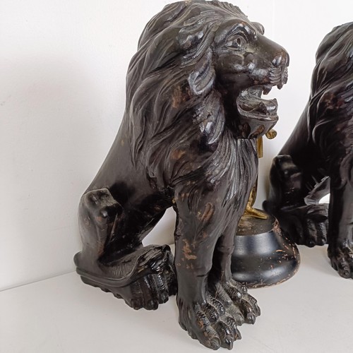 850 - A pair of carved wooden lions, 36 cm high, and a brass figure of a centurion (3)