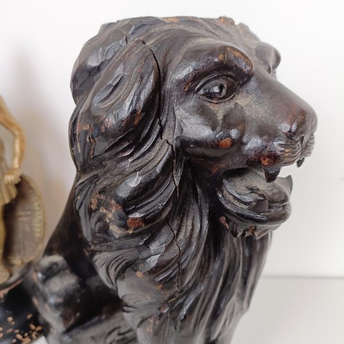 850 - A pair of carved wooden lions, 36 cm high, and a brass figure of a centurion (3)