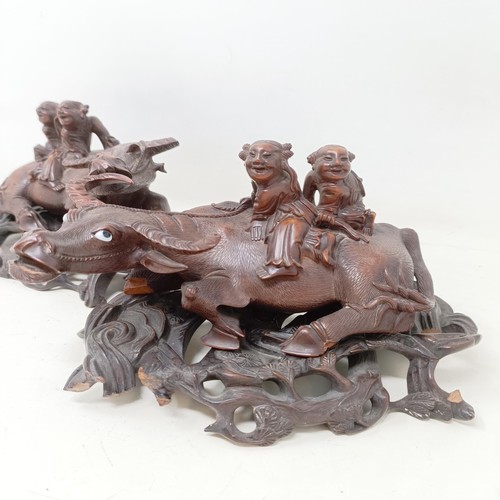 908 - A pair of Chinese carved wooden buffaloes, on stands, 21 cm wide (2)