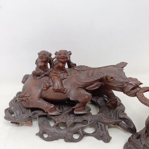 908 - A pair of Chinese carved wooden buffaloes, on stands, 21 cm wide (2)