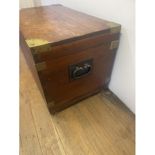 966 - A late 19th/early 20th century teak and brass bound trunk, with wrought iron handles, 100 cm wide