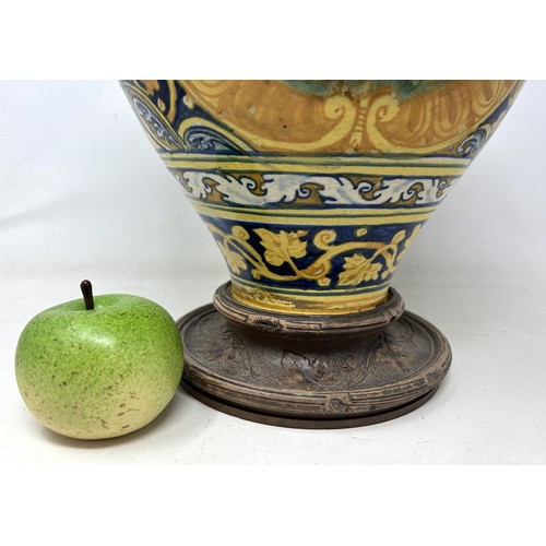 887 - A late 16th century Faience pharmacy jar, decorated saint, with a carved wooden base, 40 cm