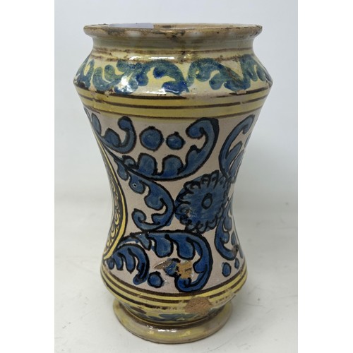 893 - An 18th century provincial albarello, probably Southern Italy, decorated foliate forms, 21 cm high