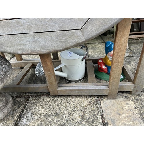 1093 - A wooden drop leaf garden table, a wooden bench, a watering can, a garden gnome, a stone planter, tw... 