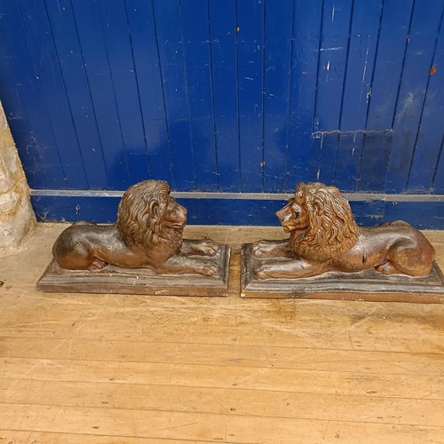 1081 - A pair of stoneware garden lions, on rectangular bases, 75 cm wide